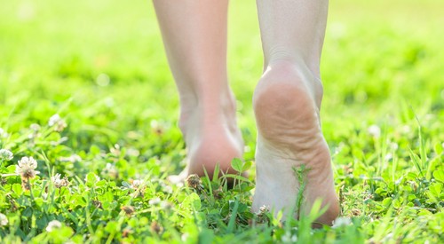 la donna sta camminando senza scarpe sull'erba